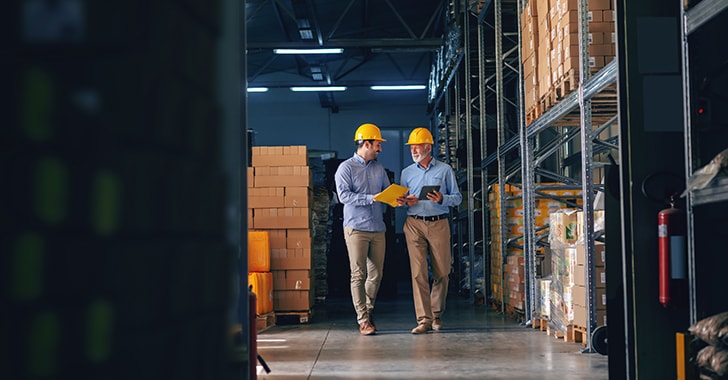 two business man walking through manufacturing business