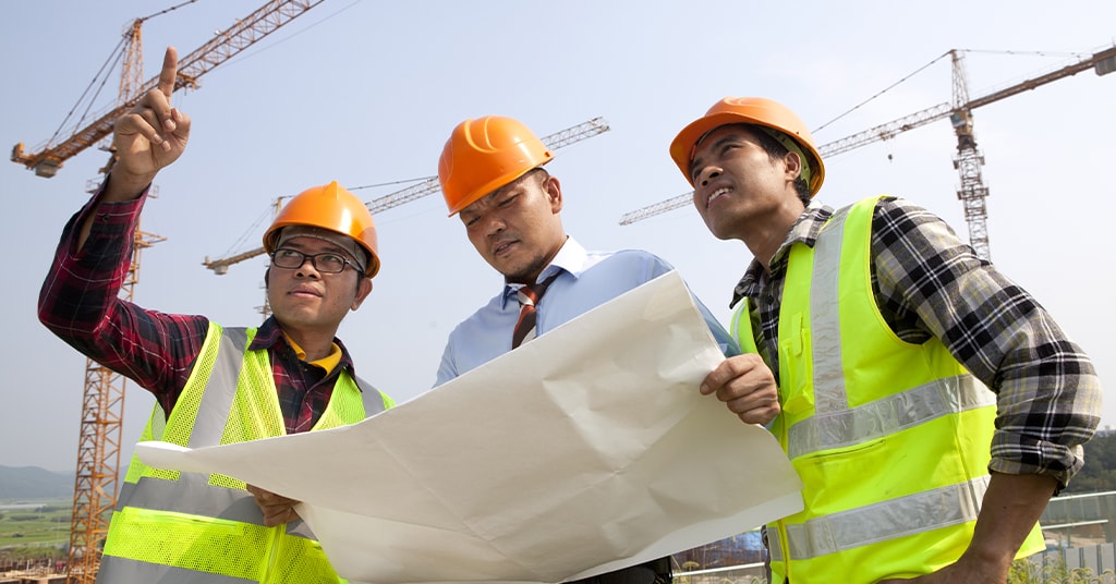 three contractors going over blueprint