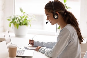 woman sitting at desk with her headset on