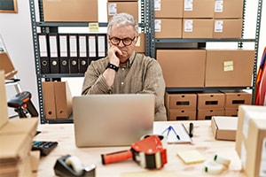 business owner working on laptop to sell business