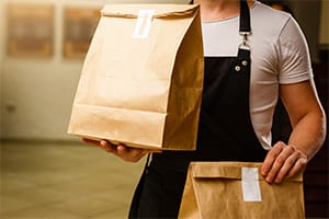 an employee holding fast food packages