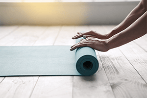 yoga student rolls up yoga mat