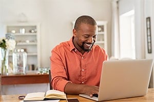 man working on his computer at home