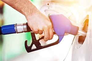 man pumping fuel into his car gas tank
