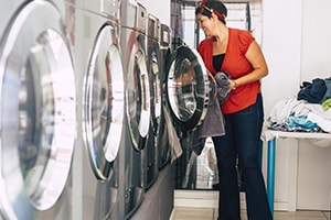 woman doing laundry at laundromat 