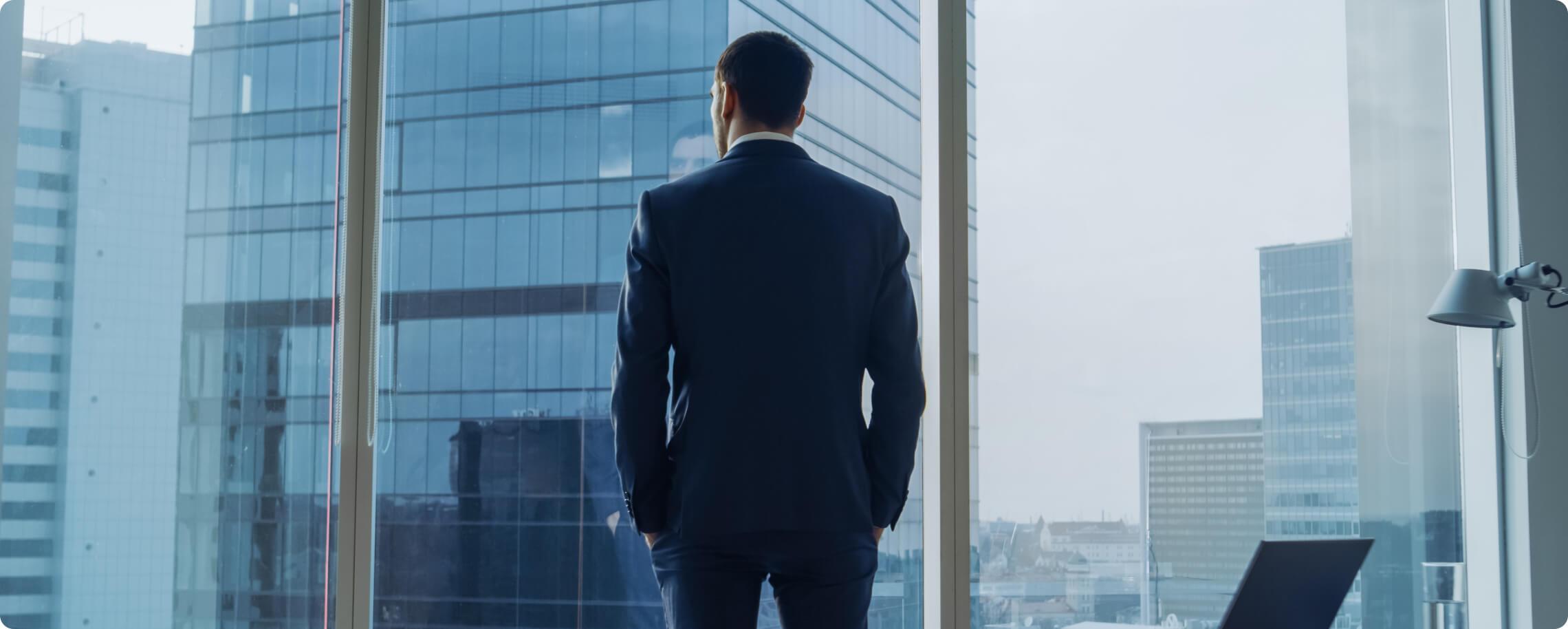 business man looking out his office window