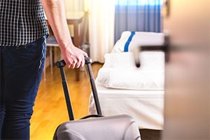 guest walking into motel room with luggage