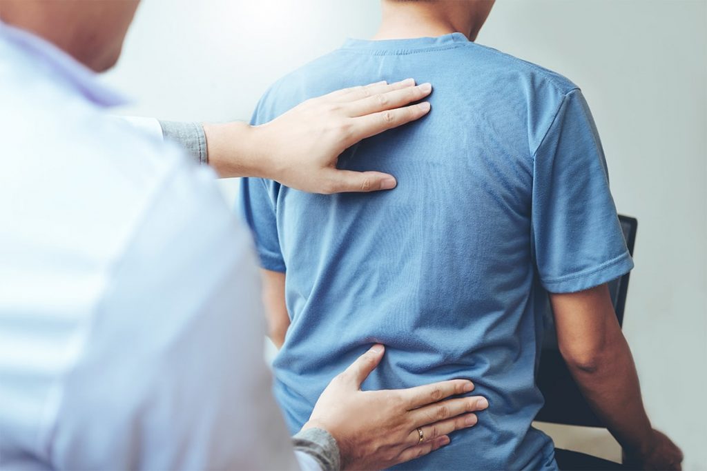 chiropractor assessing spinal health of patient