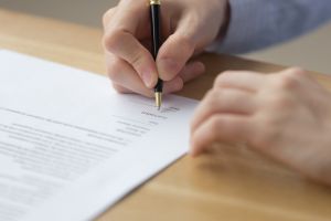 Signing a contract with pen and paper
