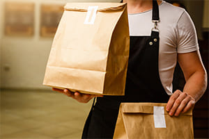 an employee holding fast food packages