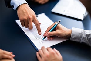 A business owner signing documents about a family business
